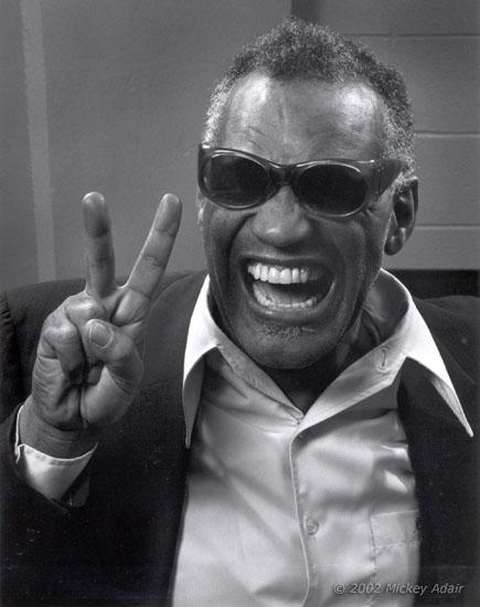 Ray Charles, grinning, holding up a peace sign