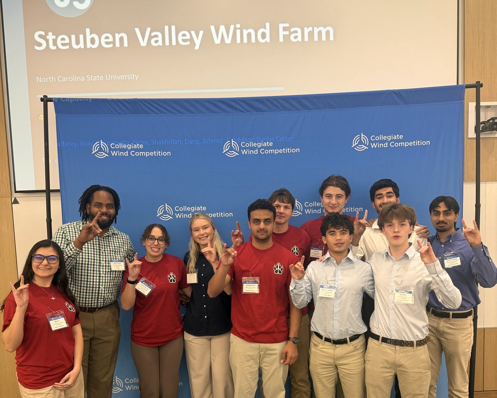 The team in front of the Steuben Valley Wind Farm title slide at competition